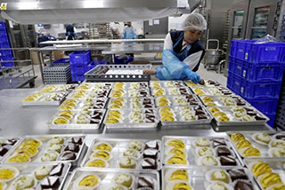 The Emirates Airlines catering facility located in the Cargo Village that serves Emirates flights along with other airlines flying out of the Dubai Airport. Dessert trays are sorted and packed. Antonie Robertson / The National